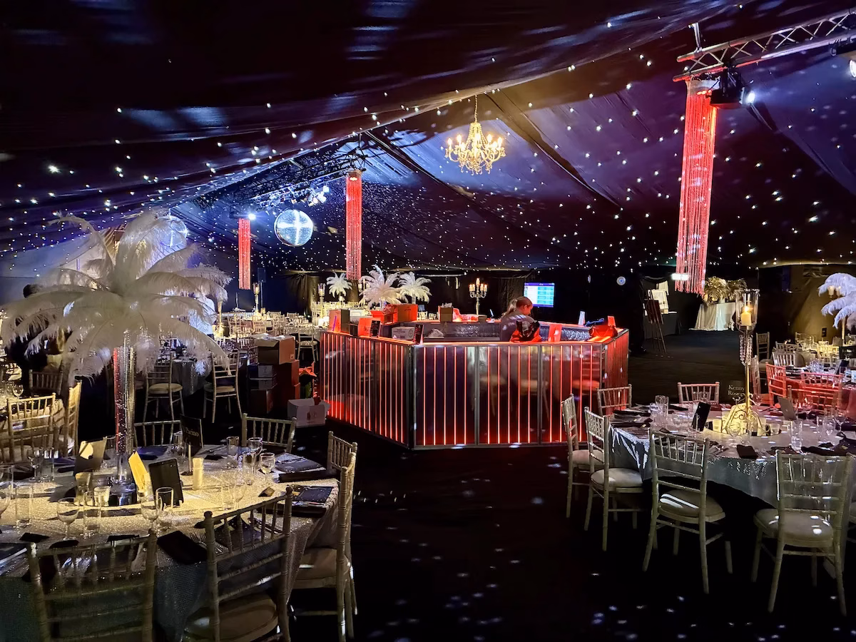 Illuminated circular mobile bar with red LED lights at a luxury festive corporate gala under a starlight marquee ceiling.